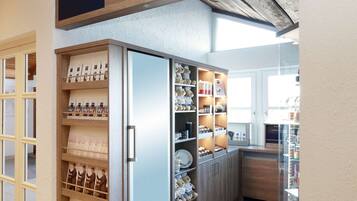A Dorint Hotels & Resorts shop with a wooden sign, a refrigerated display case, and a variety of items on shelves.