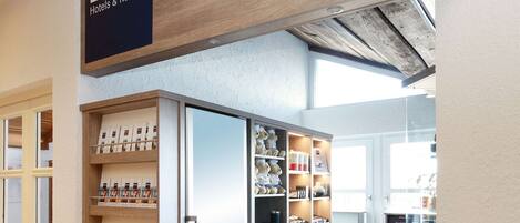 Una tienda de Dorint Hotels & Resorts con un letrero de madera, un refrigerador y varios artículos en estantes.