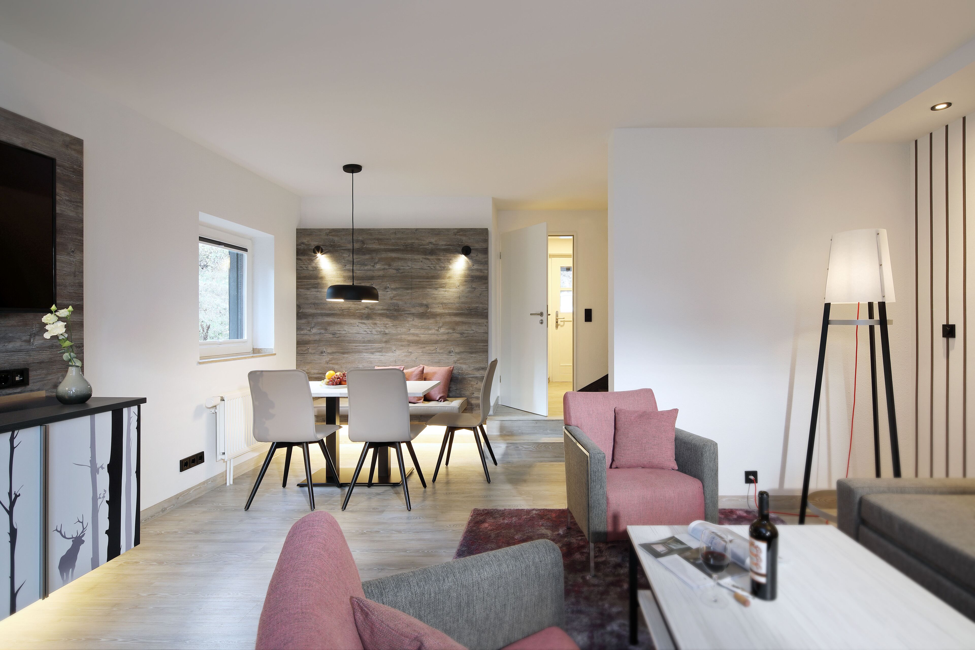 A modern living room with a dining area, a sofa, a coffee table, and a lamp.