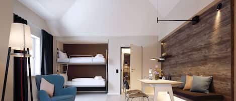 A modern hotel room with a bunk bed, a desk, a sofa, and a chair.