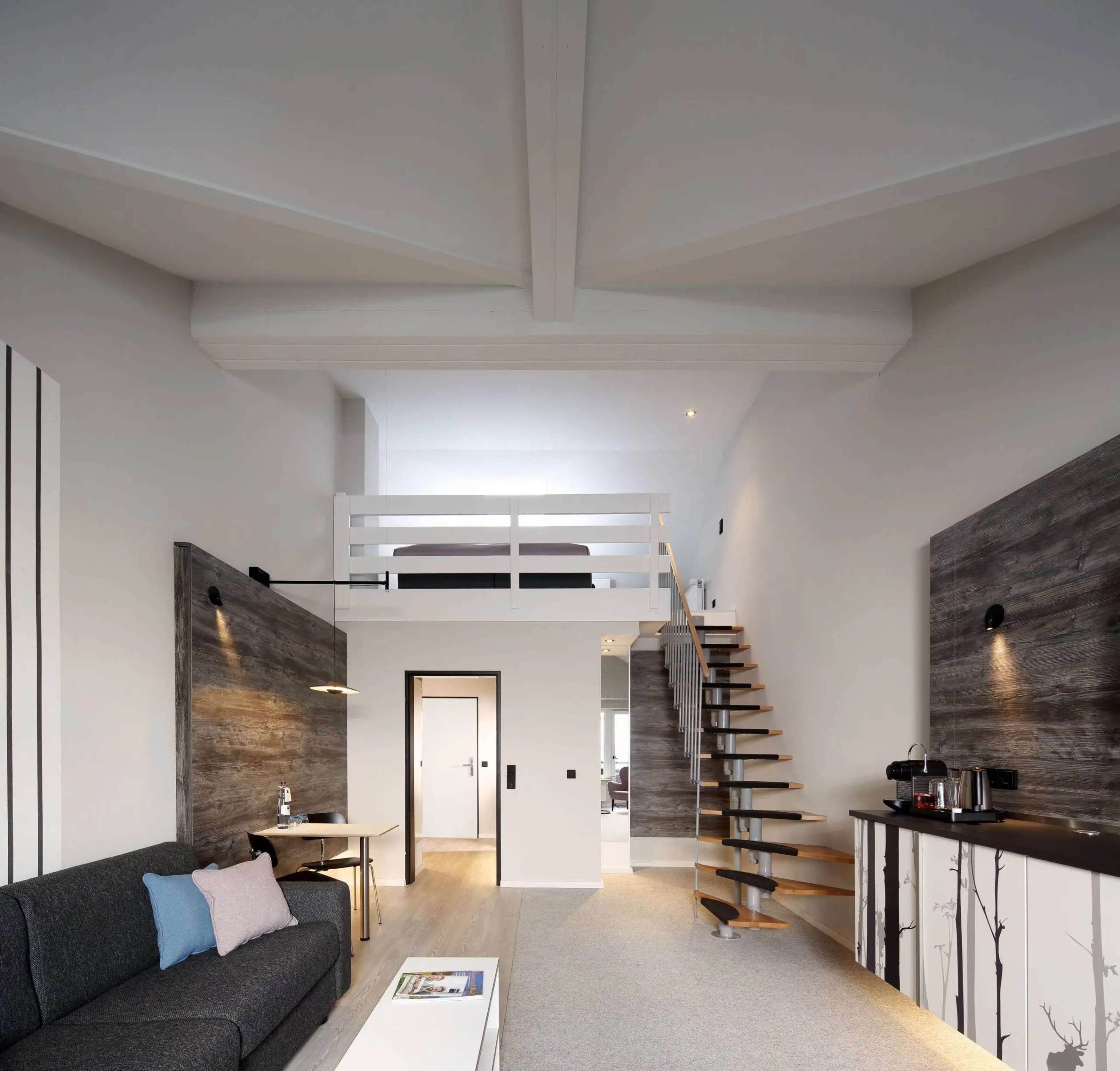 A modern living room with a sofa, coffee table, and a staircase leading to an upper level.