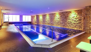 A large indoor swimming pool with stone walls and a tiled floor. - Dorint Resort Winterberg Sauerland (Winterberg)