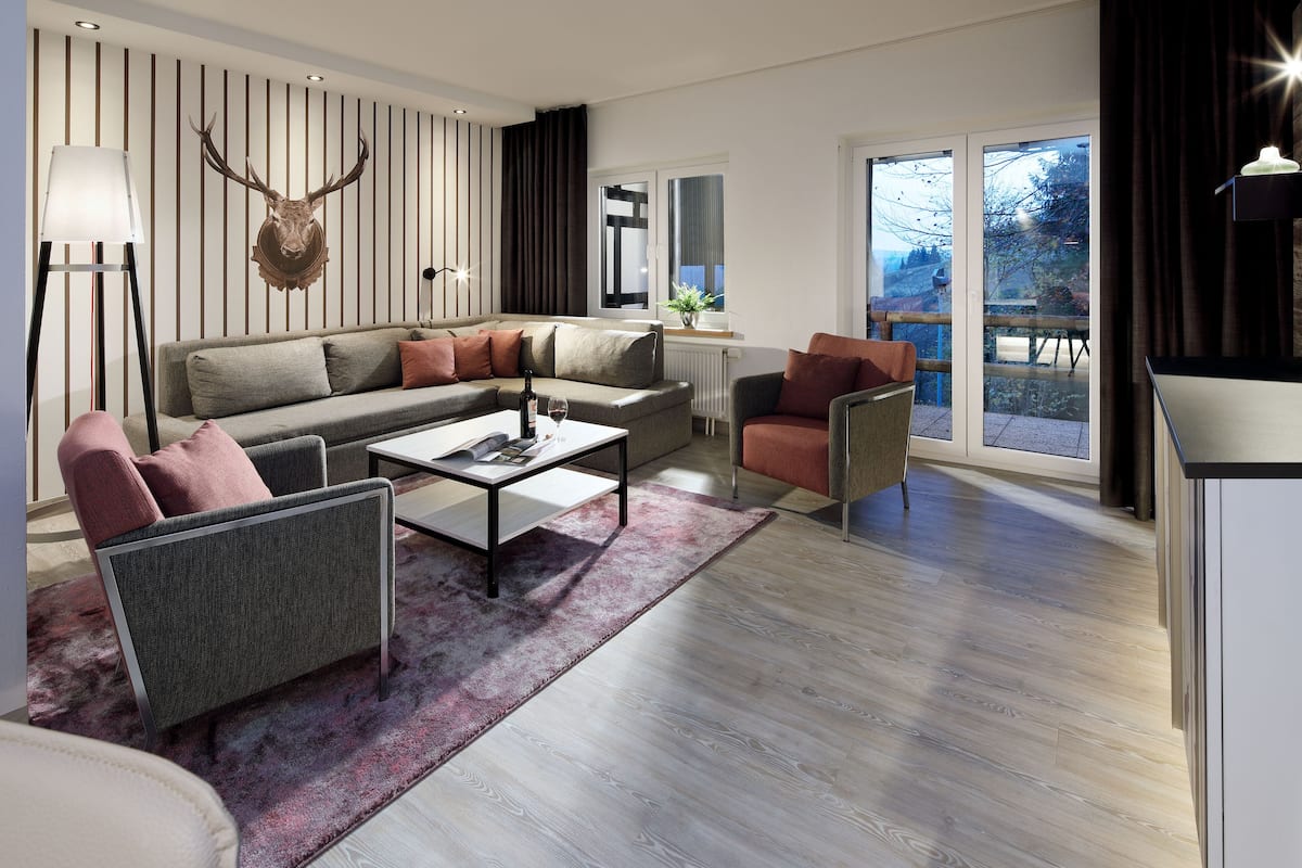 A modern living room with a sectional sofa, a coffee table, and a fireplace.