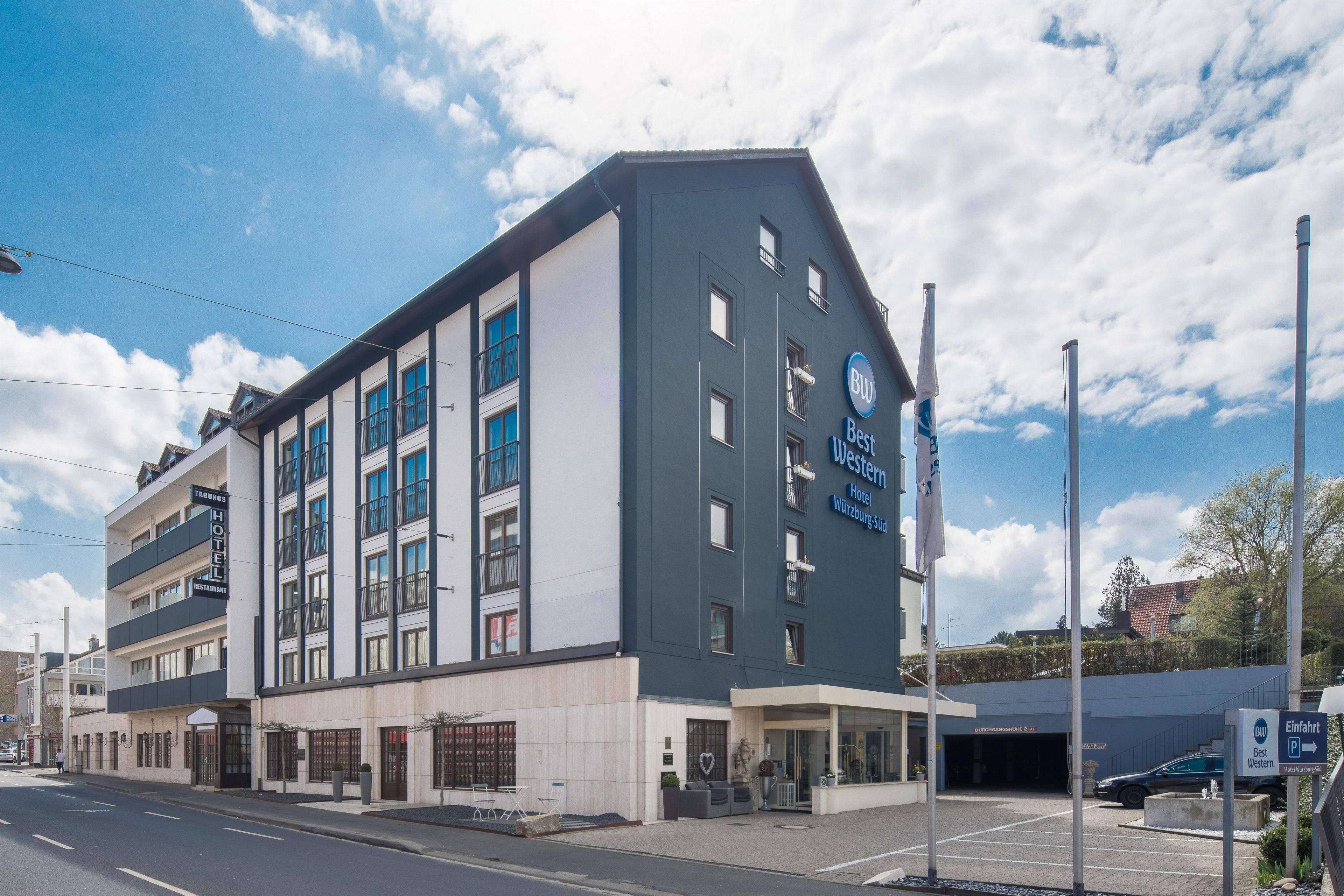En modern hotellbyggnad med en tydlig skylt med texten ”Best Western”, flera balkonger och en parkeringsplats.