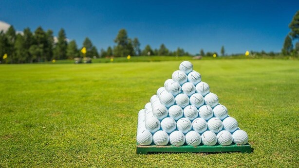 A pyramid of golf balls on a green mat on a golf course. - Best Western Hotel Wuerzburg Sued (Würzburg)