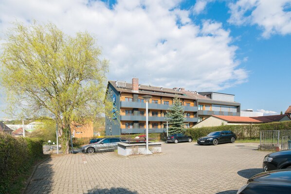 A multi-story building with a parking area in front.