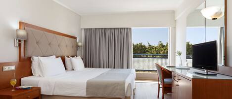 A hotel room with a bed, bedside table, TV, and a balcony with a view.