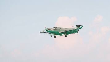 A small aircraft flying over a calm sea.