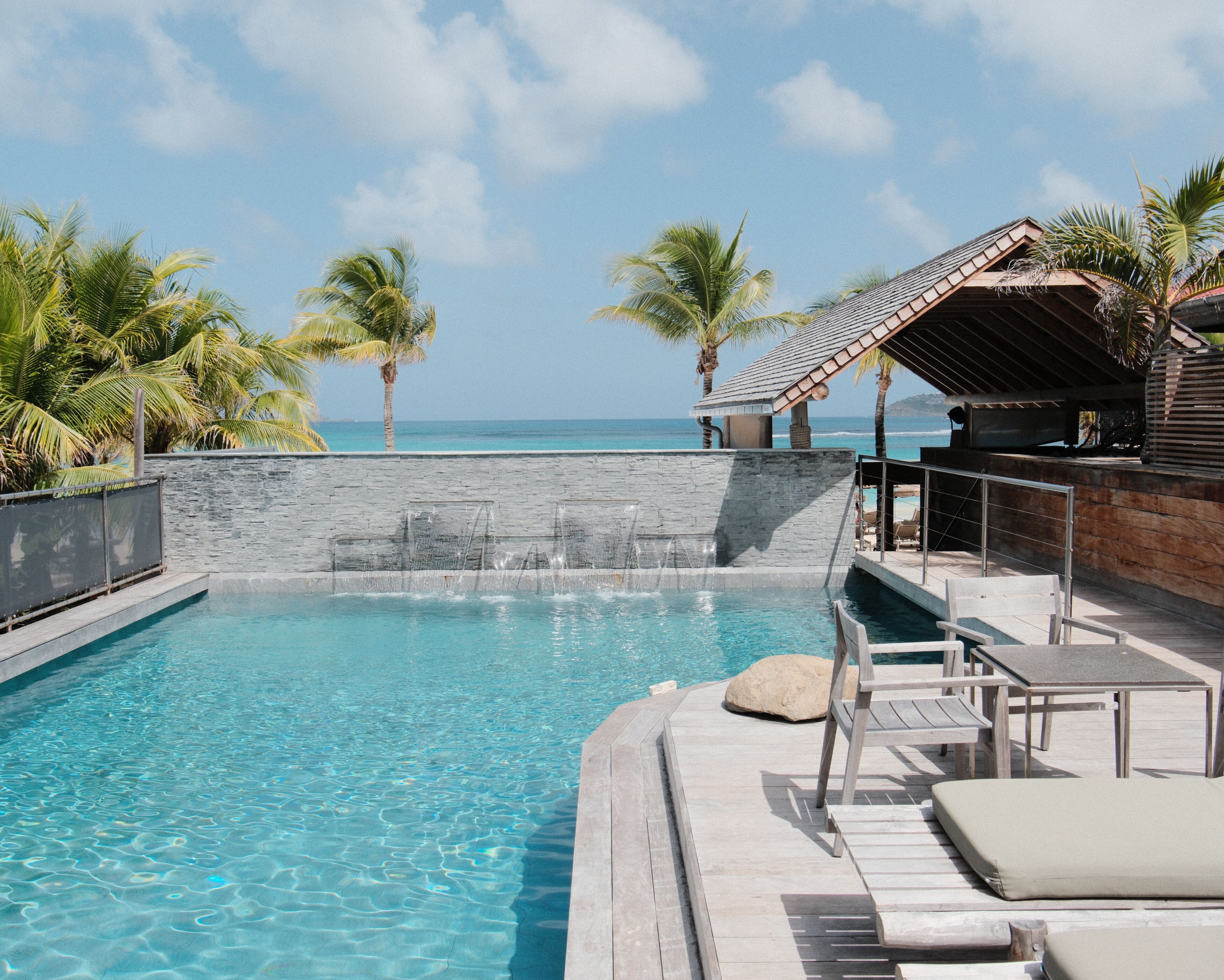 Una piscina al aire libre, sillones reclinables de piscina