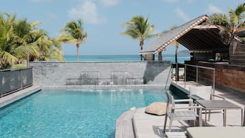 Una piscina al aire libre, sillones reclinables de piscina