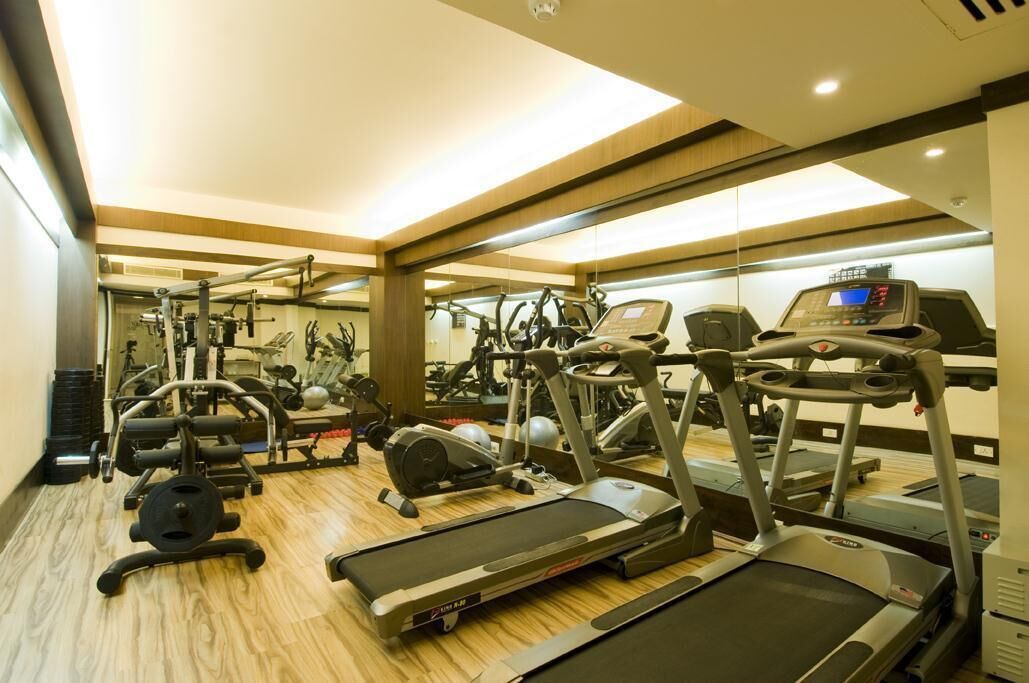 A gym with treadmills, elliptical machines, and weightlifting equipment.