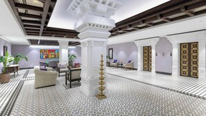 A spacious lobby with a high ceiling, patterned floor tiles, and a central white column. - Vivanta Ernakulam, Marine Drive (Kanayannur)