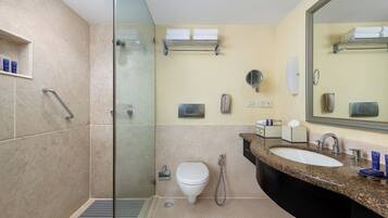 A modern bathroom with a glass-enclosed shower, a sink with a vanity, and a toilet.