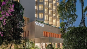 A hotel with a modern design, featuring multiple balconies and a well-lit facade. - Vivanta Ernakulam, Marine Drive (Kanayannur)