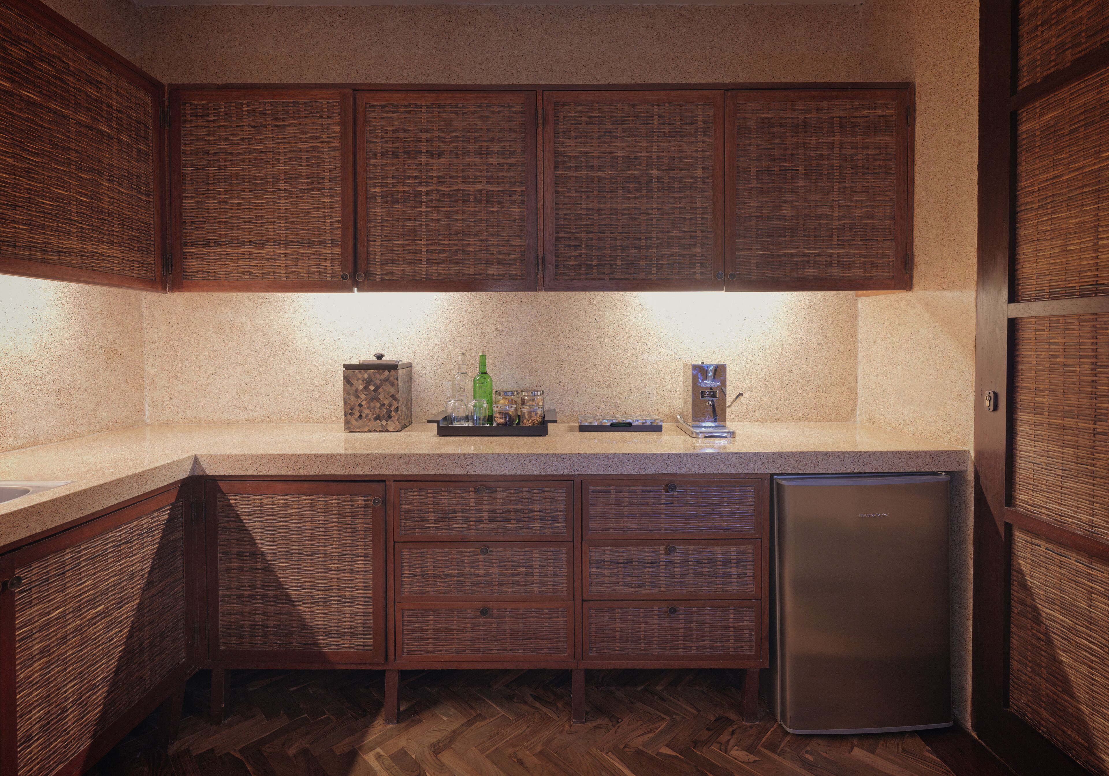 A kitchen with wooden cabinets, a built-in refrigerator, and a countertop with various items.