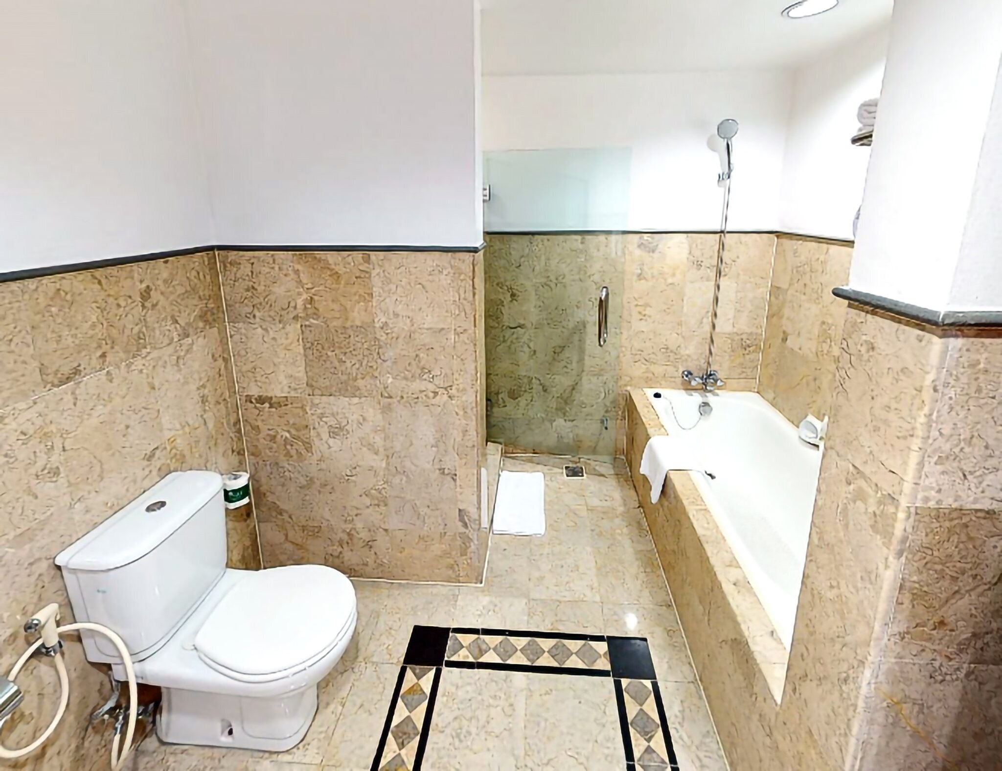 Une salle de bain équipée de toilettes, d’une baignoire et d’une douche.