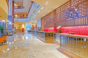 A spacious lobby with a high ceiling, a reception desk, and a decorative wall with intricate patterns. - Millennium Hotel Sirih Jakarta (Jakarta)