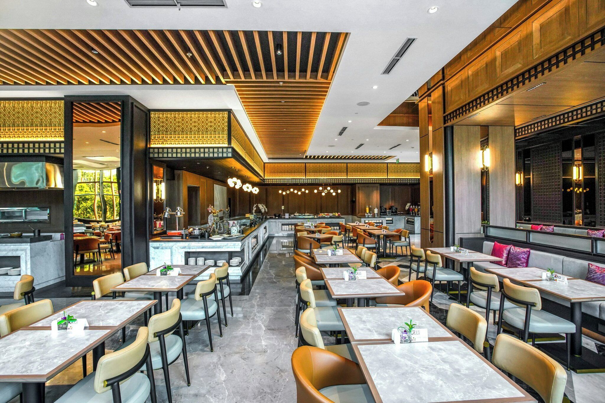 A modern restaurant with multiple dining areas, a bar, and a view of the outdoors.