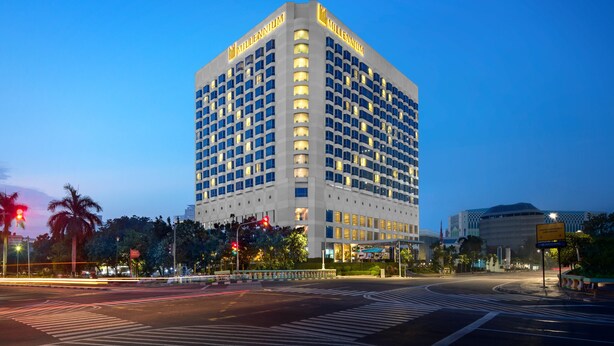 Un hotel de varios pisos con diseño moderno, que destaca un cartel prominente que dice “MILLENNIUM” en la parte superior.
