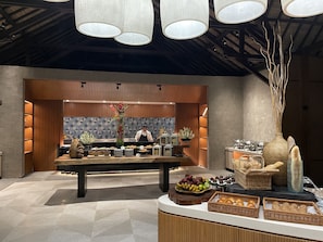 Une cuisine moderne dotée d’un îlot central, de meubles en bois et d’un vase décoratif orné de fleurs.
