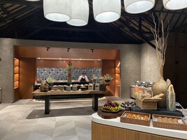 A modern kitchen with a central island, wooden cabinets, and a decorative vase with flowers.
