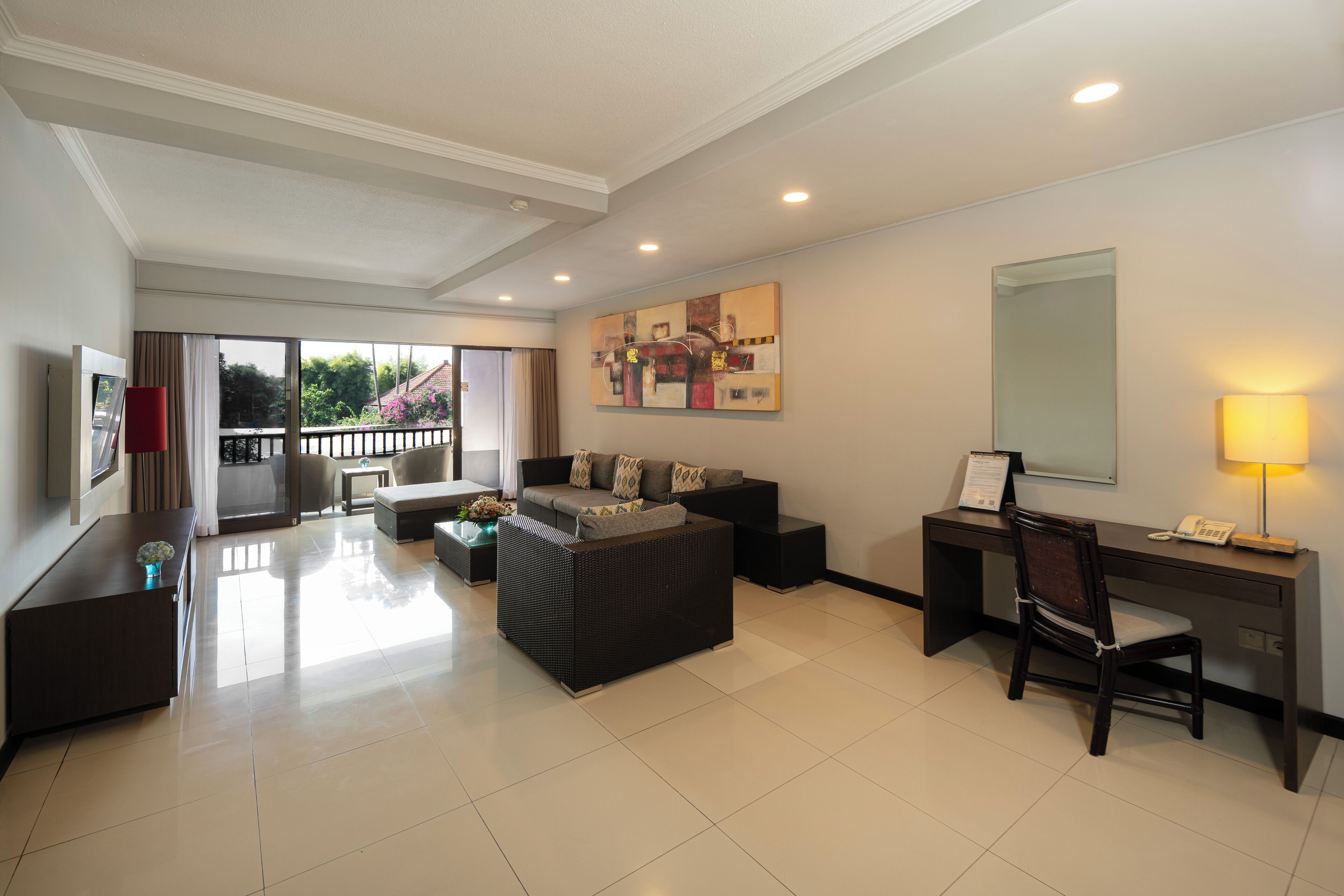 Une chambre d’hôtel moderne avec un balcon, un canapé, un bureau et une chaise.