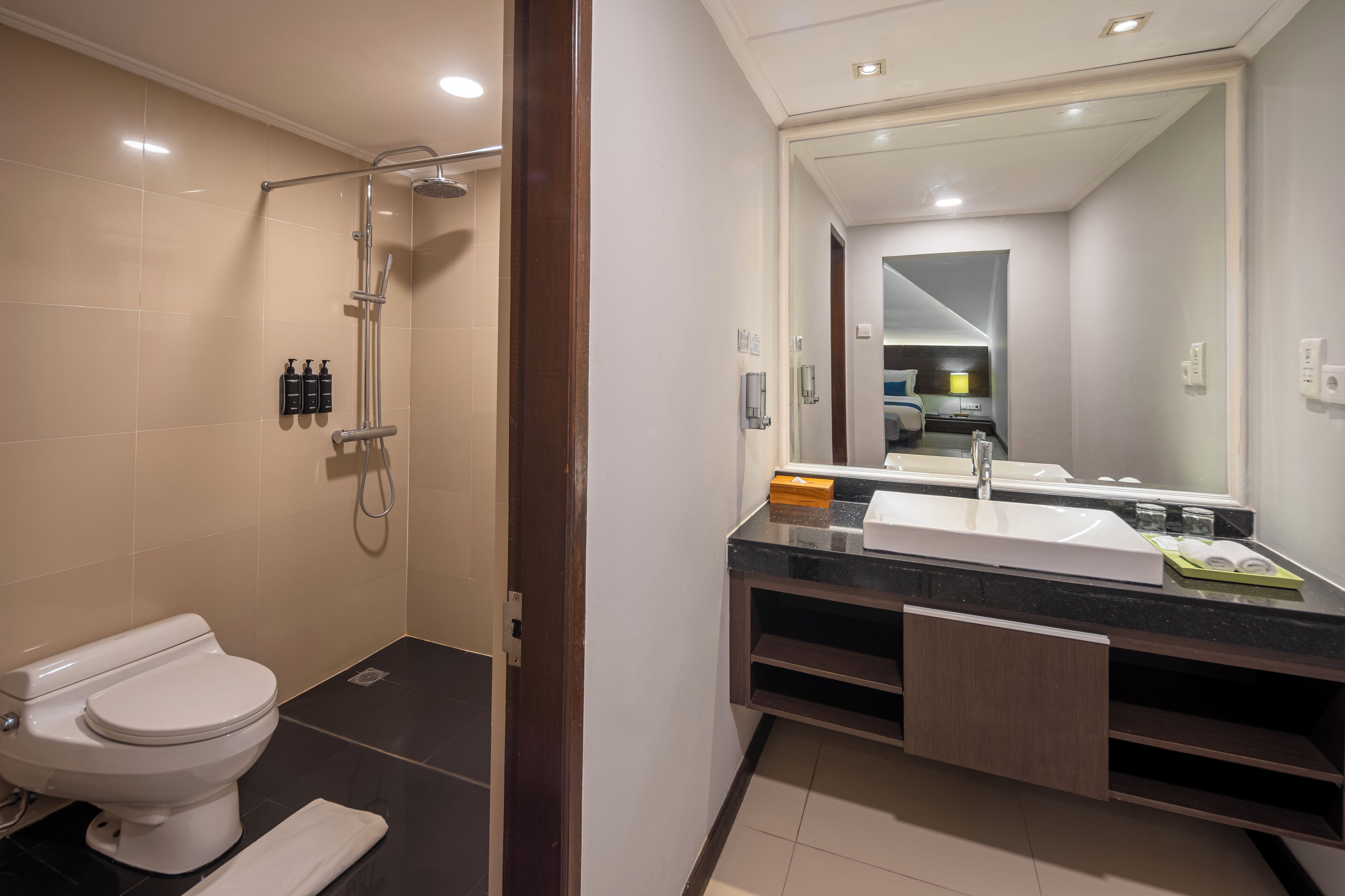 A modern bathroom with a toilet, shower, and sink.