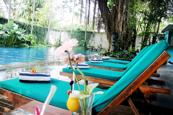 Una piscina al aire libre, tumbonas