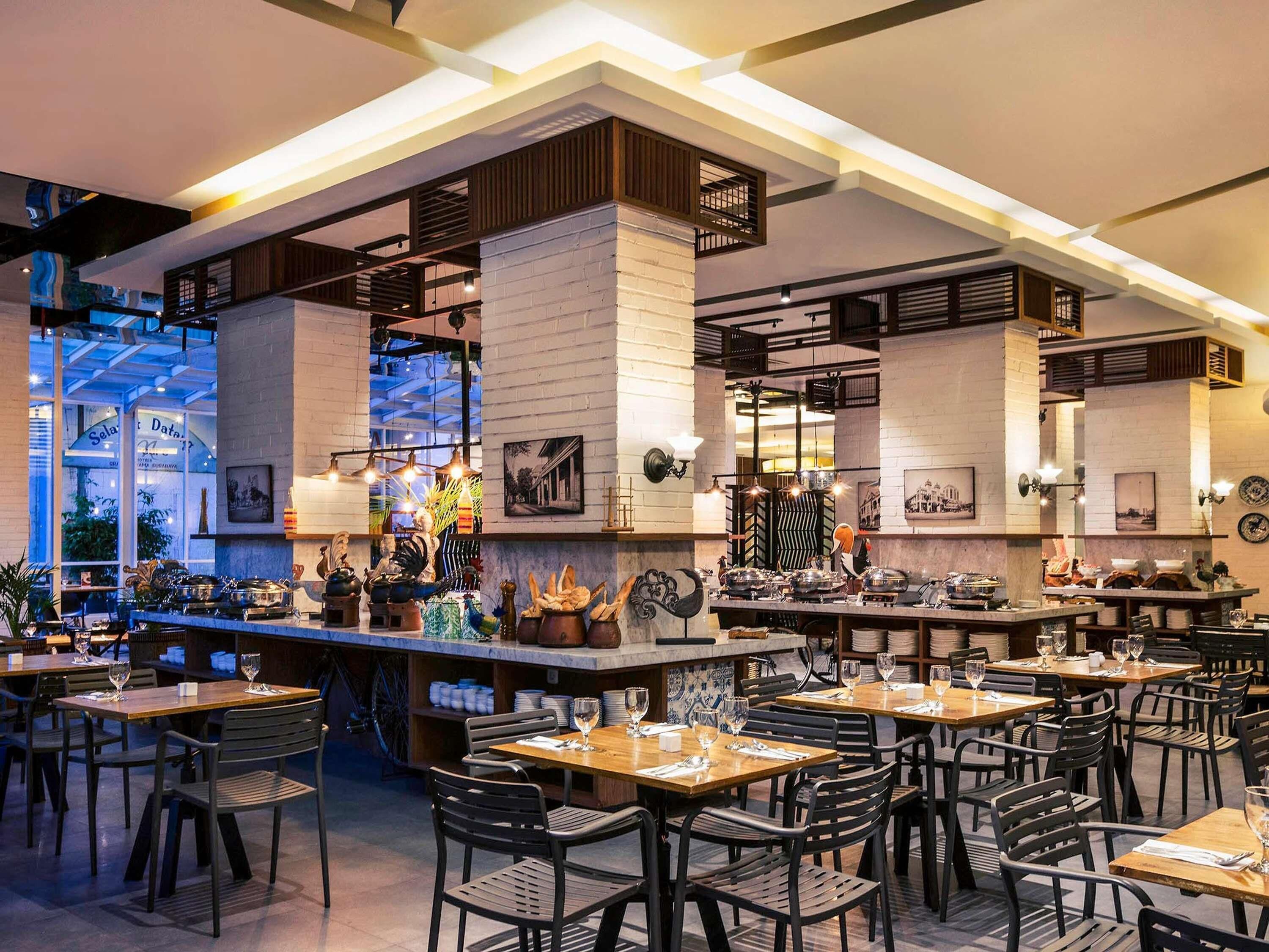 A restaurant with multiple dining tables and chairs, a bar area, and a view of the street outside.