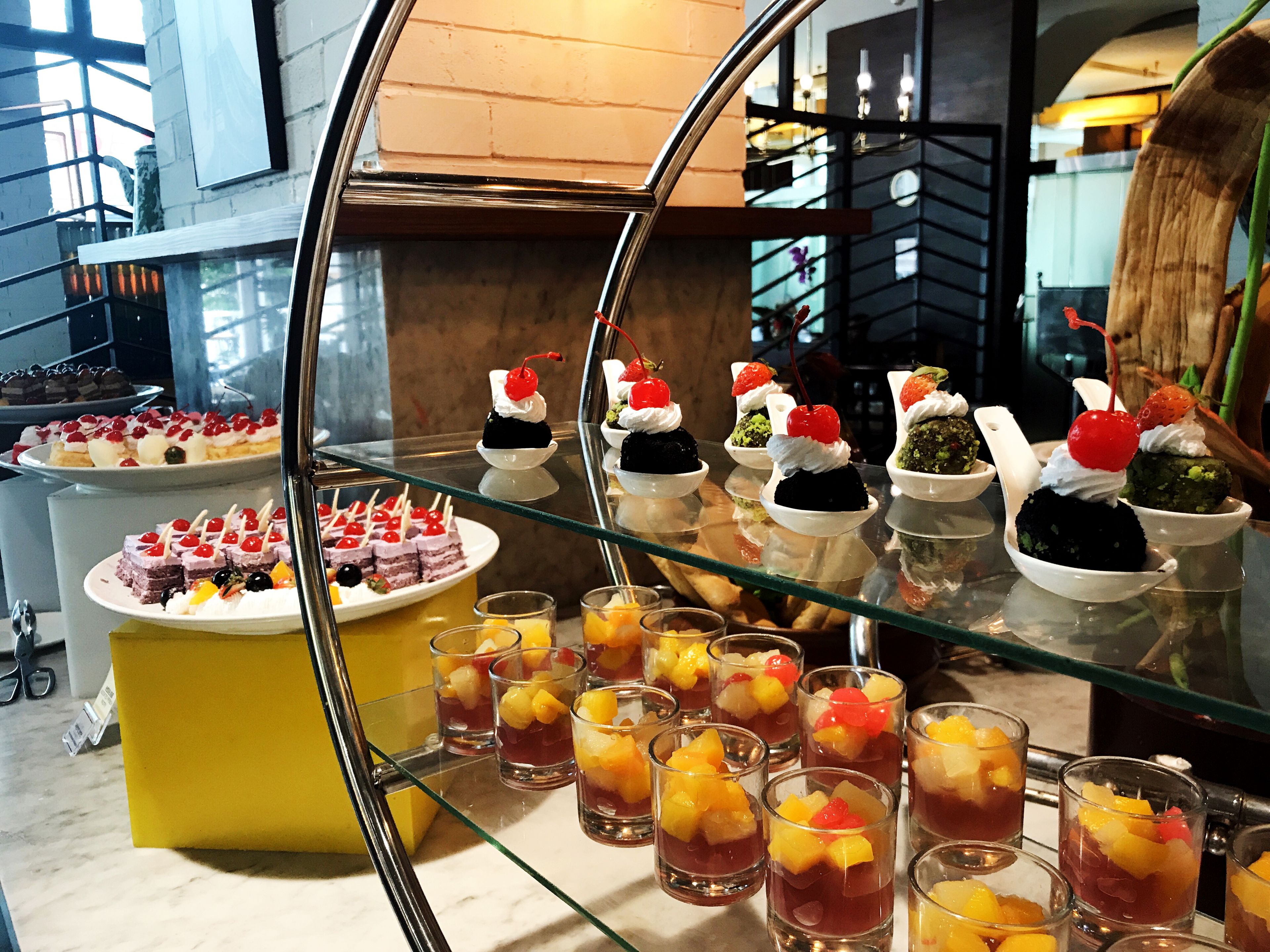 Una presentación de postres con varios pasteles y bebidas a base de fruta.