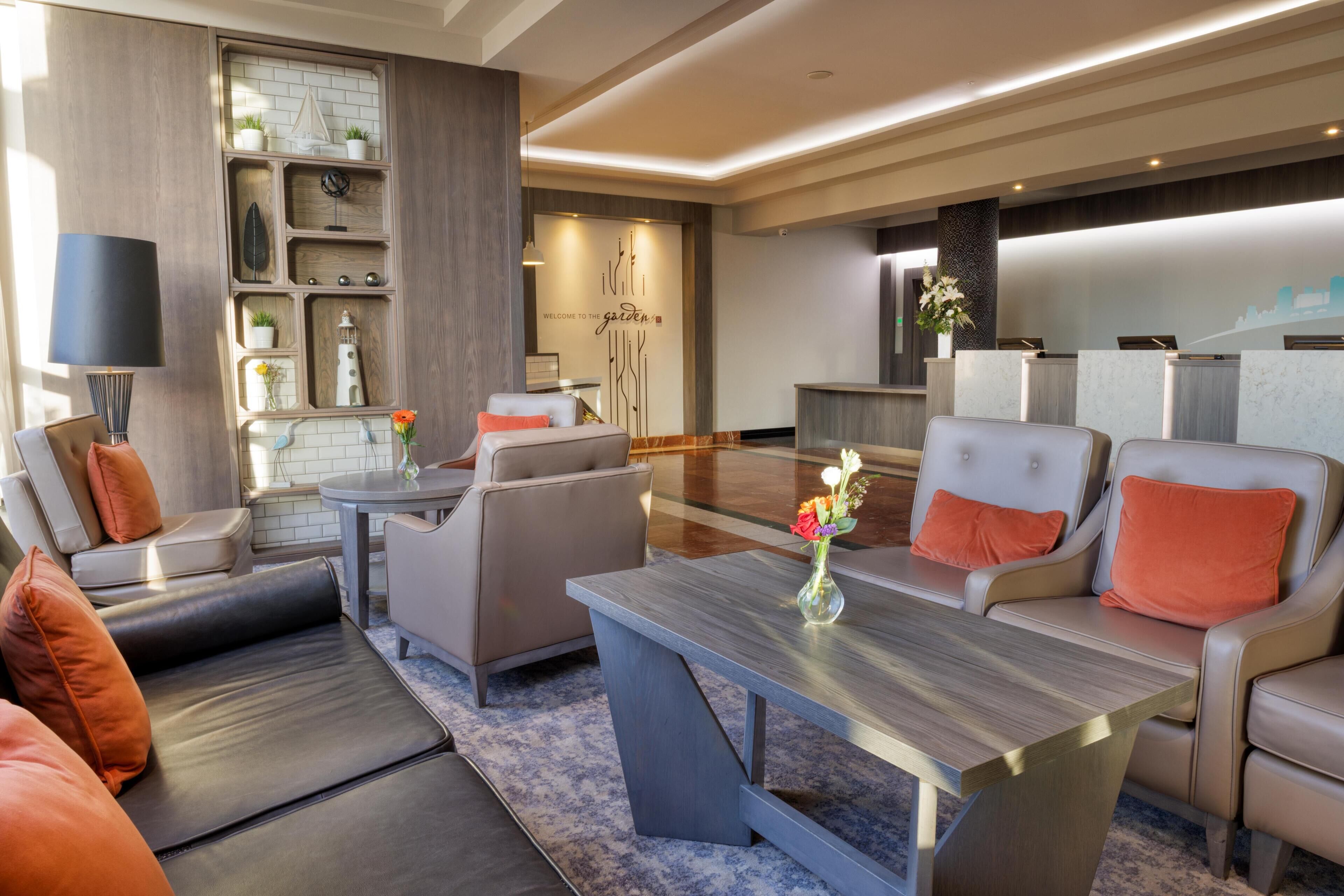Un hall d’hôtel moderne avec des canapés en cuir, une table basse et un comptoir d’accueil.