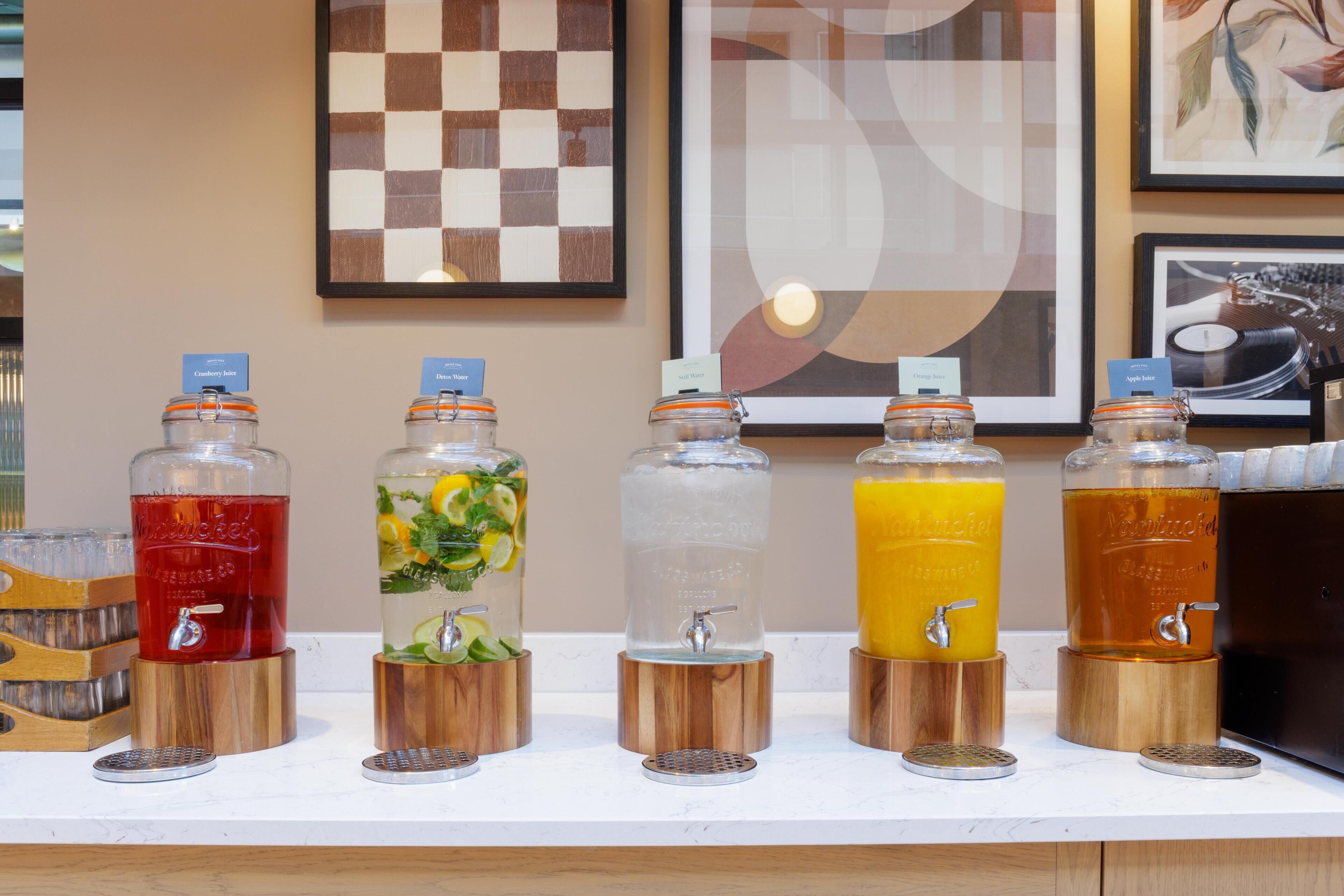 Un dispensador de bebidas con cinco opciones diferentes, cada una con su etiqueta.