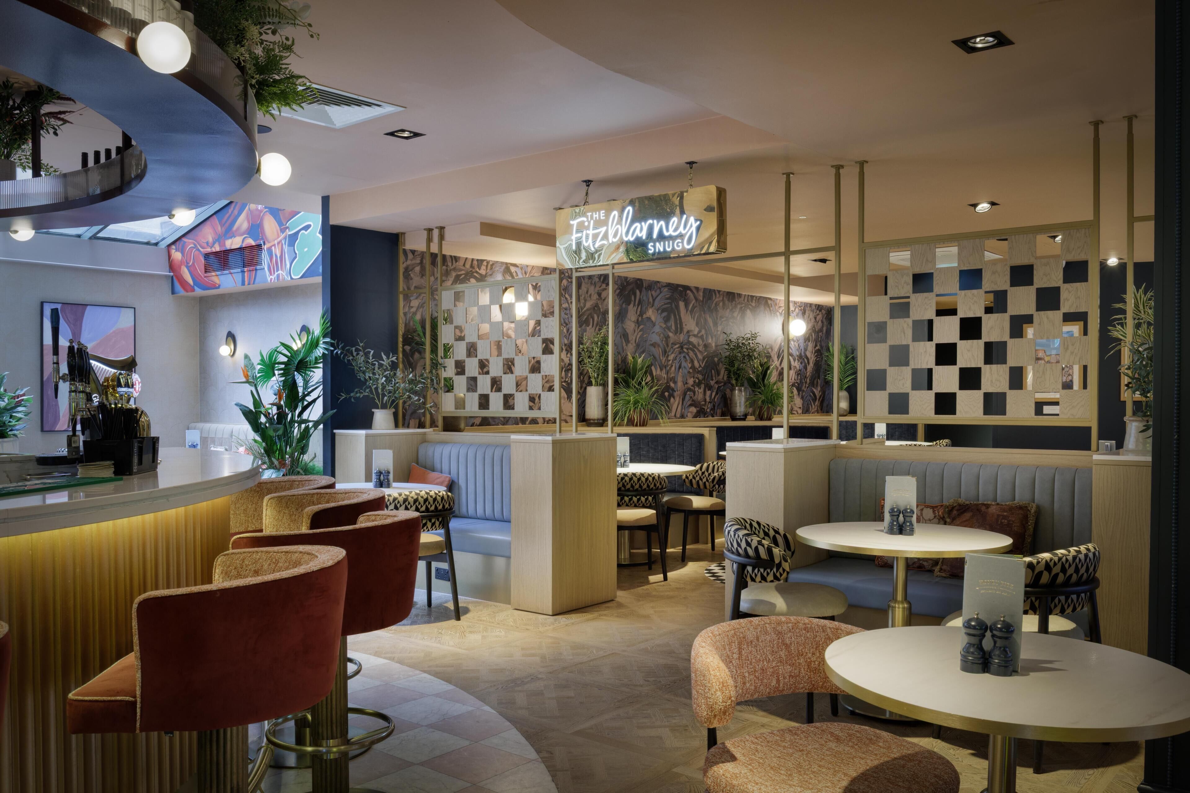 A modern restaurant interior with a bar area, seating arrangements, and decorative elements.