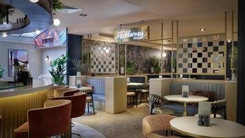 A modern restaurant interior with a bar area, seating arrangements, and decorative elements.