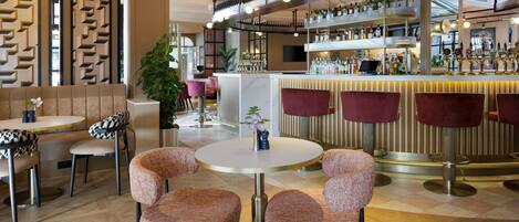 A bar area with multiple seating options, a bar counter, and a variety of bottles and glasses.