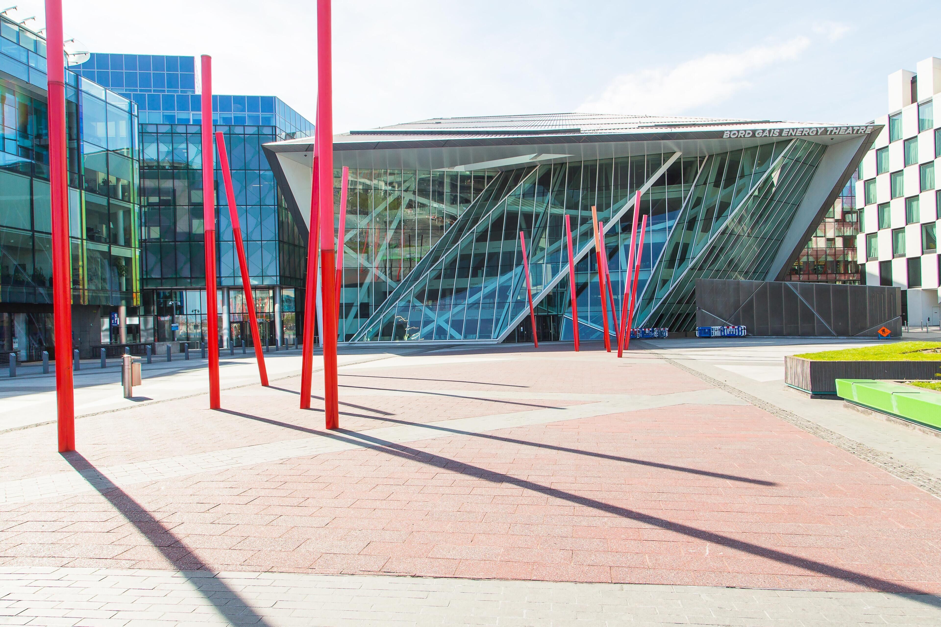 A modern building with a glass facade, red structural elements, and a sign indicating it's the Bord Gais Energy Theatre.