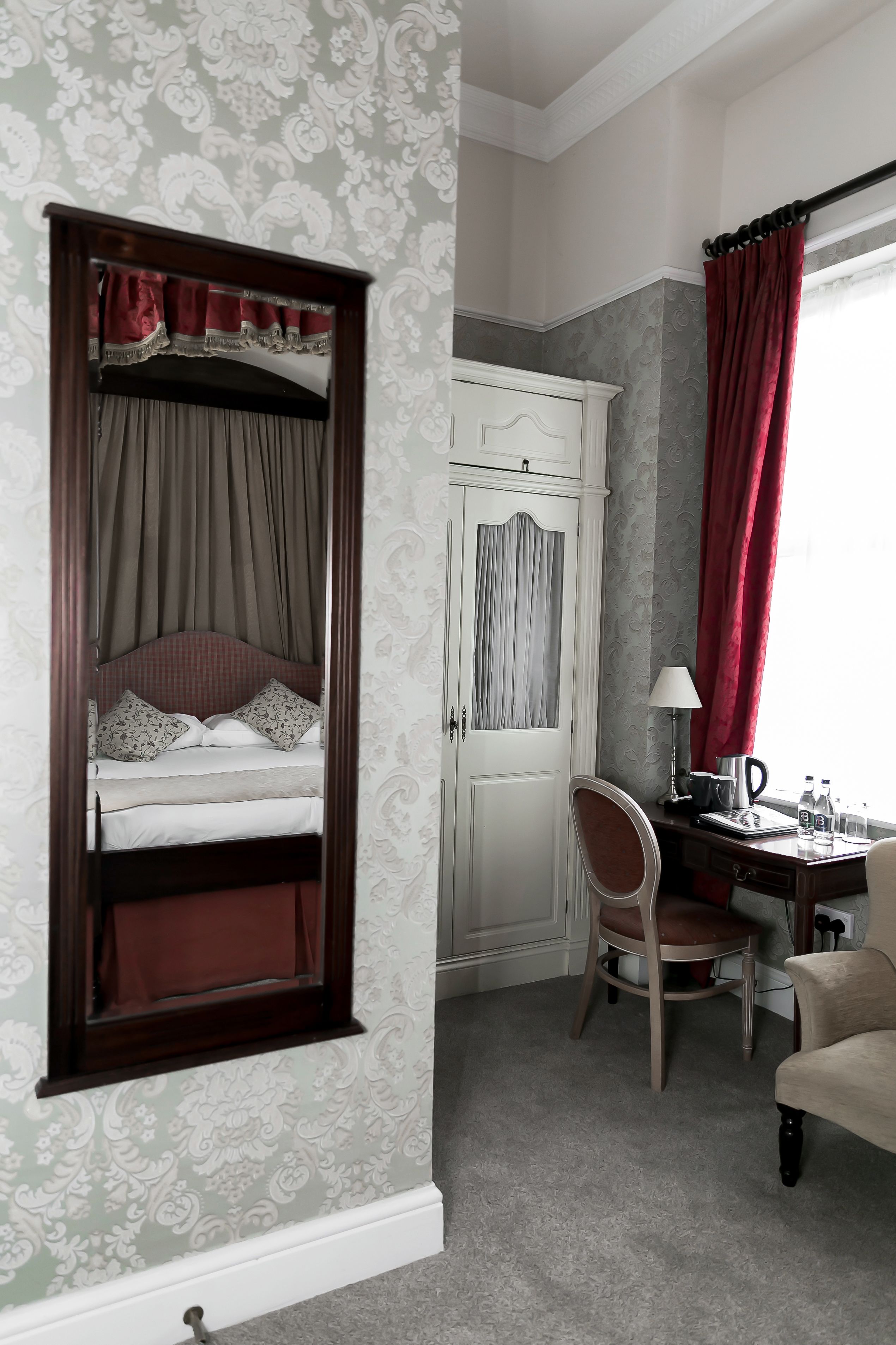 A bedroom with a bed, a desk, and a chair.
