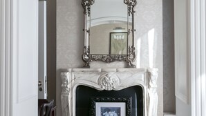 A room with a white fireplace, a large ornate mirror above it, and a framed picture below. - Butlers Townhouse (Dublin)