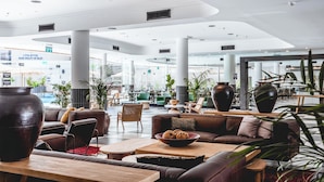 A spacious lobby with leather sofas, a coffee table, and large vases. - Jacob Eilat (Eilat)