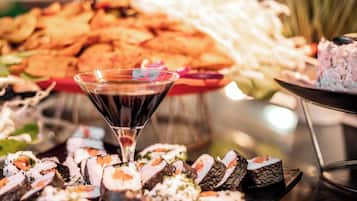 Una variedad de sushi y otros platos en una bandeja, con una copa de martini en el centro.