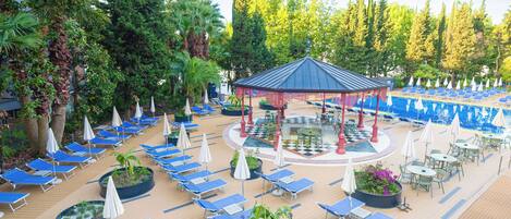 A resort with a gazebo, sun loungers, and a pool area.