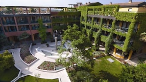 Un patio central con una fuente, rodeado de edificios con plantas trepadoras verdes.