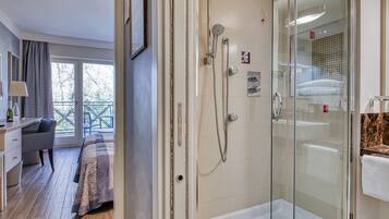 Un baño moderno con ducha de vidrio, bañera y retrete.