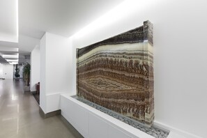 A modern interior with a large, striped wall art piece. - Mercure Villa Romanazzi Carducci Bari (Bari)