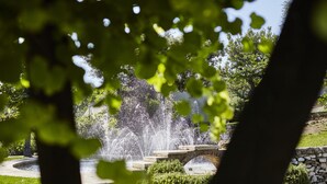 A stone bridge over a fountain in a park with lush greenery. - Mercure Villa Romanazzi Carducci Bari (Bari)