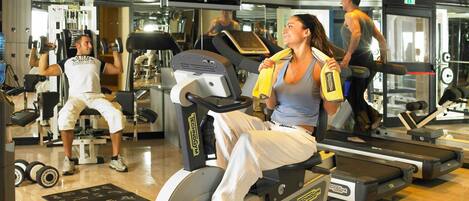 A gym with stationary bikes, treadmills, and weight machines.