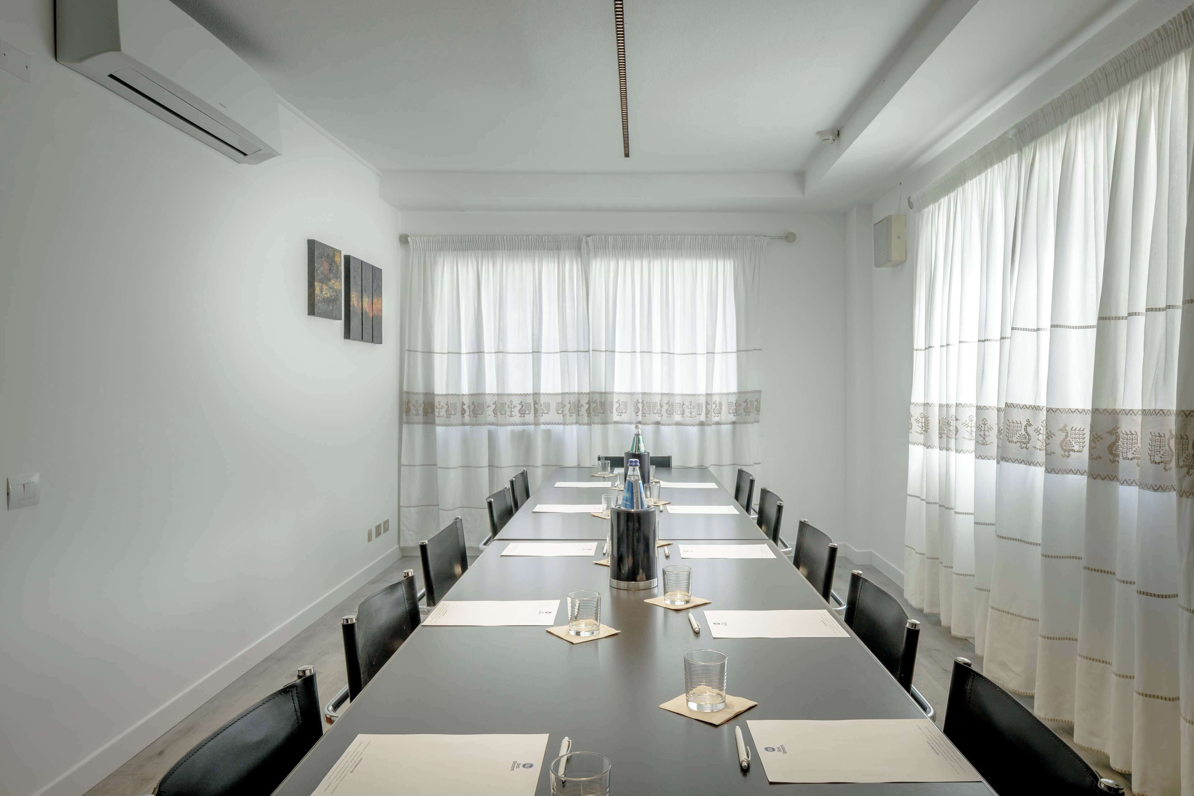 Une salle de conférence équipée d’une longue table, de chaises et d’un projecteur.