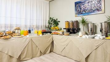 Un buffet de petit-déjeuner proposant une variété d’aliments, de boissons et agrémenté d’un tableau accroché au mur.