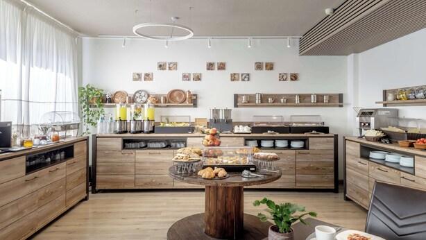 Una cocina moderna con armarios de madera, una isla central con exhibición de alimentos y una estación de café.