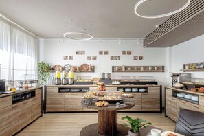 Een moderne keuken met houten kastjes, een centraal eiland met etalage voor voedsel, en een koffiehoek.
